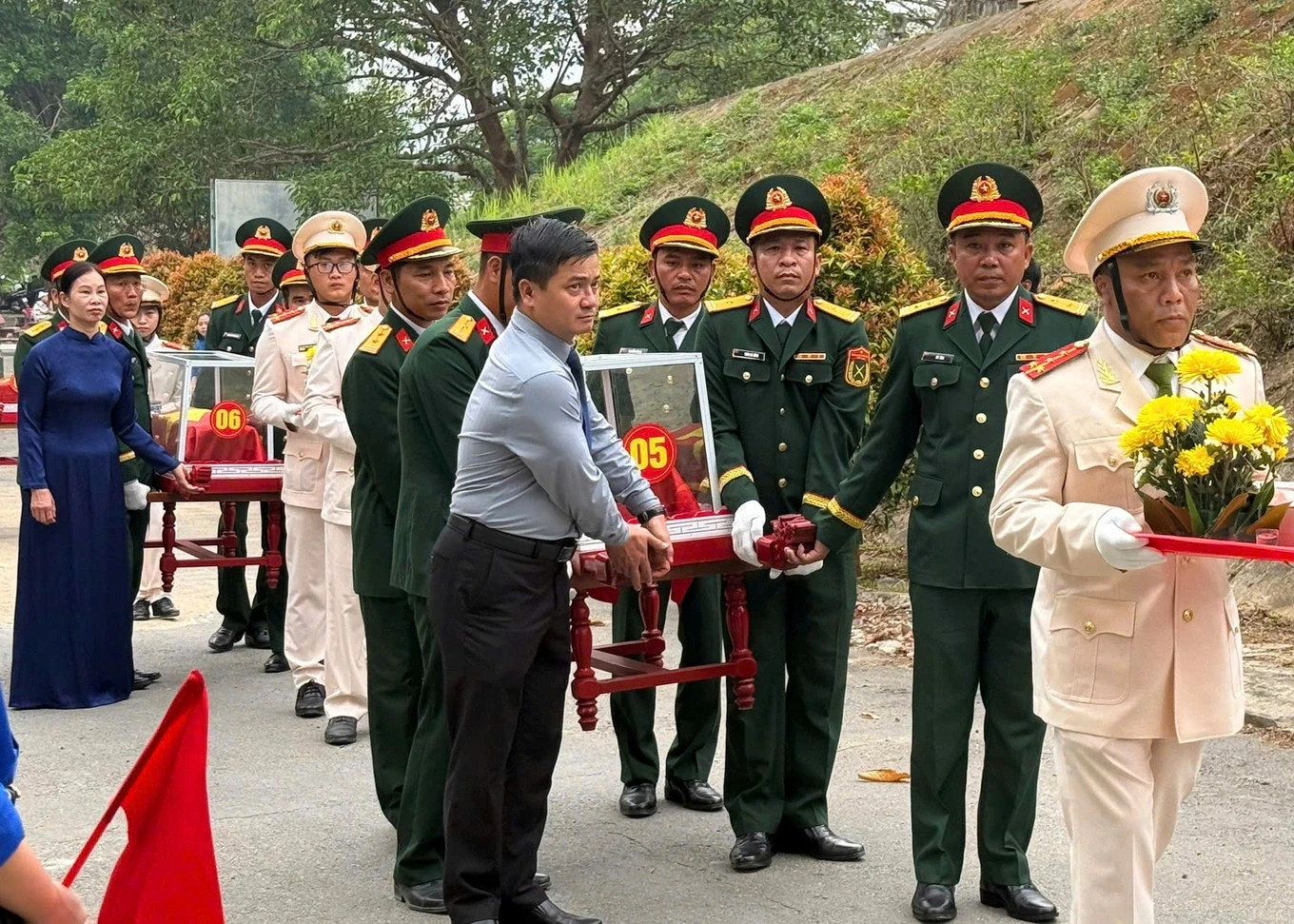 Lãnh đạo chính quyền địa phương và lực lượng vũ trang đưa hài cốt liệt sỹ về khu vực an táng (Ảnh: Võ Đông).